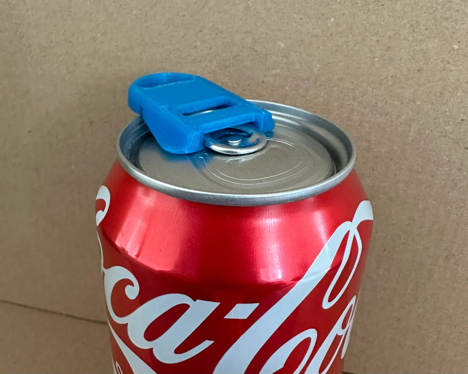 Bryans3dPrints 2-in-1 Soda Can Opener & Lid, blue plastic, attached to a Coca‑Cola can